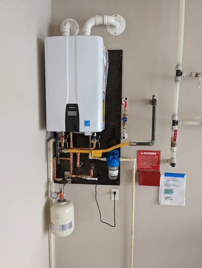 Professional plumber installing copper piping in a Buena home